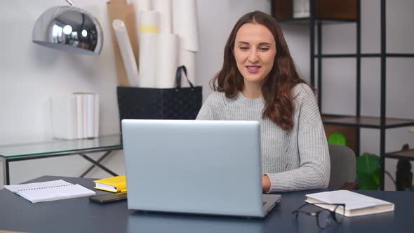 Cheerful Young Woman Has Video Call on the Laptop at Office