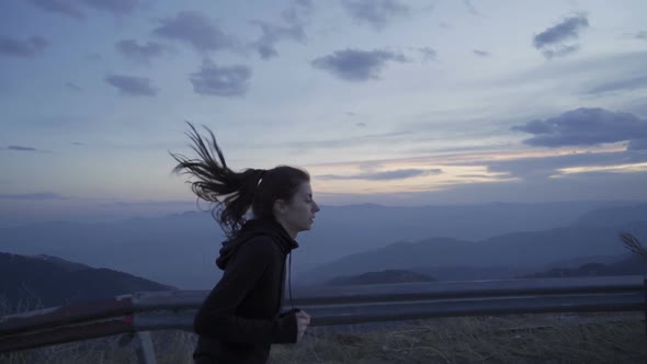Exhausted Woman Sprinting, Jogging in the Mountain at Sunset Reaching the Top