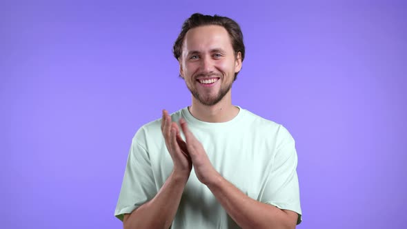 Smiling European Man is Applauding Isolated Over Violet Studio Background