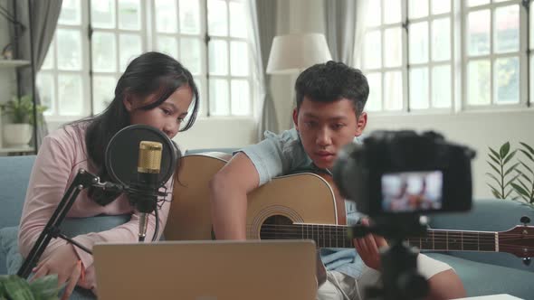 Asian Boy With Guitar And Girl Read Comment On Laptop While Live Streaming