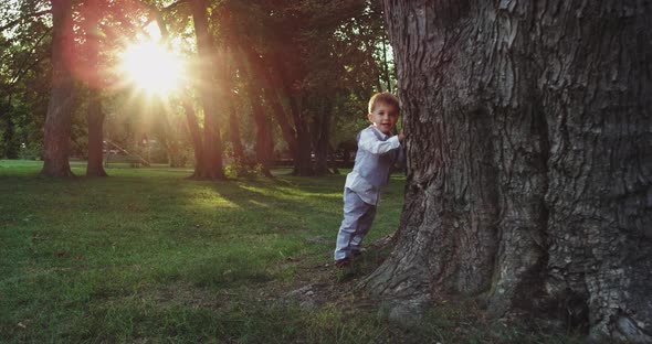 Very Cute and Funny Boy Hiding Out Beside of a Big