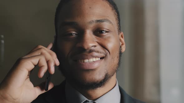 Closeup Smiling Black Business Man Talking Mobile Smartphone in Office