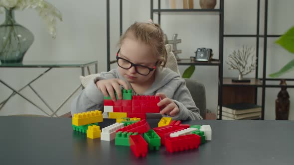 Little Girl with Down Syndrome Playing with Toy Blocks