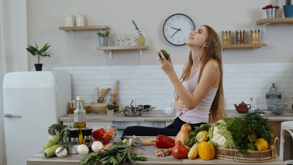 Girl Recommending Eating Raw Vegetable Food. Showing Avocado in Hands. Weight Loss and Diet Concept