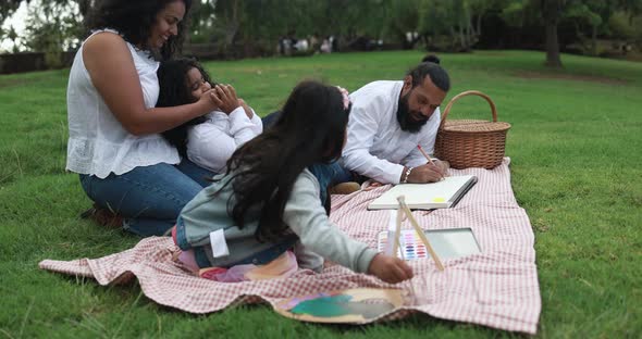 Indian parents having fun at city park painting with their children