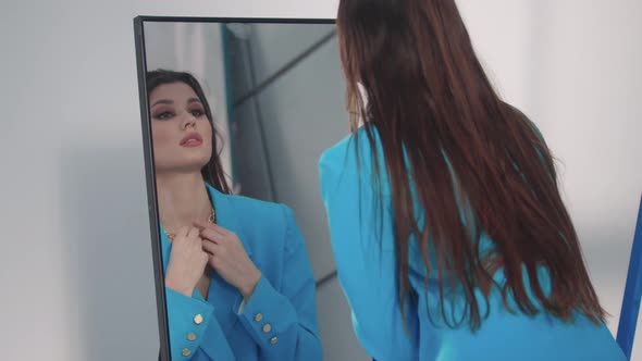 A Young Pretty Woman in a Blue Blazer Flaunts Herself in Front of a Mirror