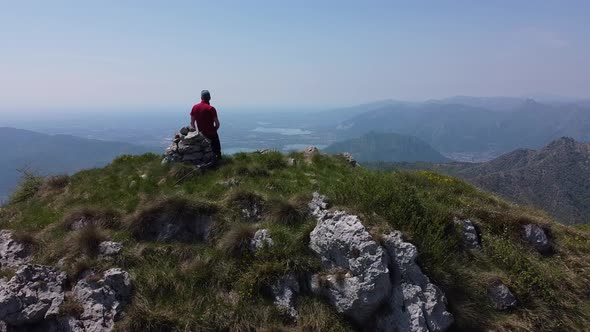 Hiker on top of mountain peak, European Alps, Lecco, Italy