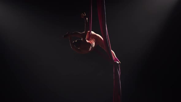 Young Female Circus Gymnast Spins on Aerial Silk and Demonstrates Stretching