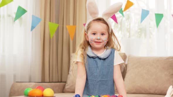 Funny Beautiful Little Girl Blonde Jumps in the White Ears of a Rabbit