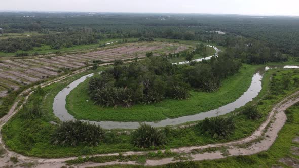 Aerial fly over the curve river with cultivated land