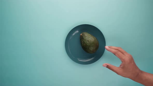 Hand Pick a Slice of Avocado From a Plate