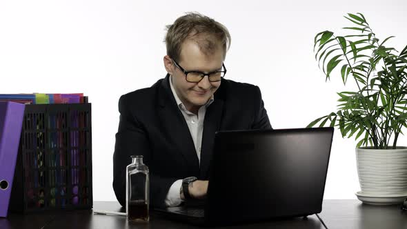 Tired Disheveled Businessman Working Hard in Office and Drink Alcohol Cognac