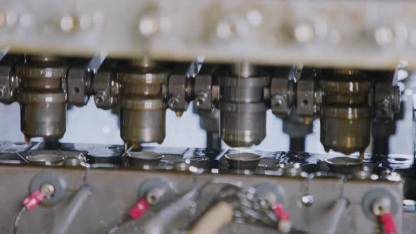 Close up of a punch press forming metal parts in a production line