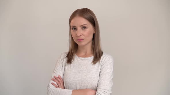Portrait of cute woman standing, looking at camera with serious attentive face