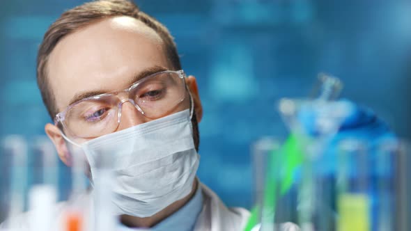 Closeup Portrait of Male Chemic Doctor Wearing Protective Mask Working on Vaccine From Virus