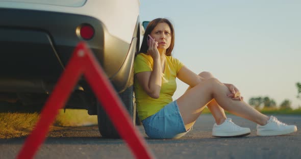 Frustrated Girl Sits Nearbroken Car on Side of Road and Calls for Help on Phone