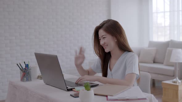 Asian woman video conferent and working online on a laptop at home