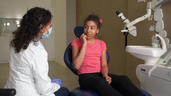 Masked Female Dentist Communicating with Patient