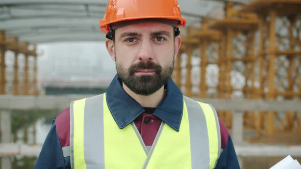 Portrait of Confident Construction Workman Wearing Safety Uniform Standing in Building Area