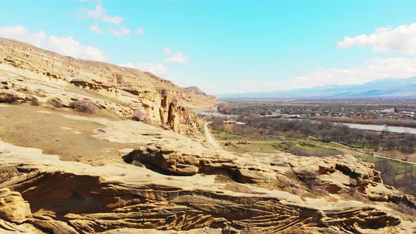 Aerial Fly Over Uplistsikhe Rocks And Blooming Spring Trees