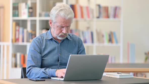 Coughing Old Man Working on Laptop