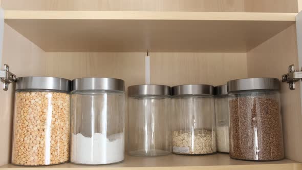 The Housewife Puts Buckwheat in the Cupboard in the Kitchen Where the Food is Stored