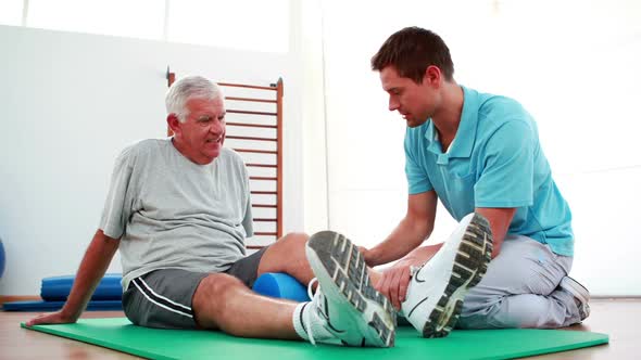 Physiotherapist Helping Patient With his Knee Mobility