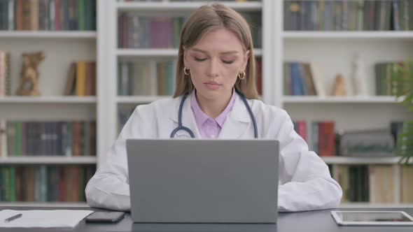 Lady Doctor Looking at Camera While Using Laptop in Clinic