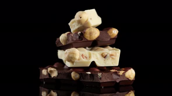 chocolate black and white with nuts. Chocolate bar on black background rotation