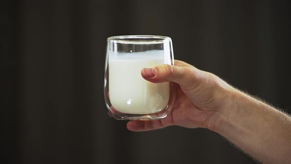 glass of milk in hand. drink for breakfast. milk clean drink for health and energy