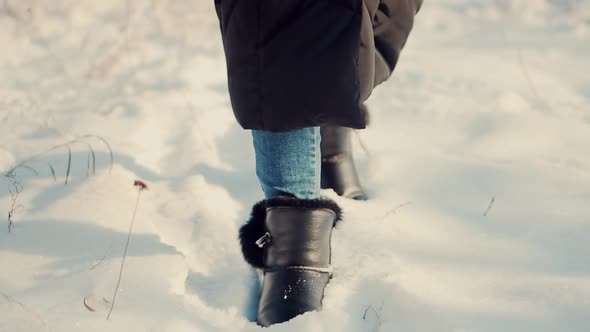 Woman Legs Walking In Snow. Female In Snowy Weather At Cold Temperature Walking Alone.Legs Footprint
