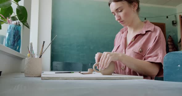 Female Potter Sitting and Makes a Cup at the Table. Woman Making Ceramic Item. Pottery Working