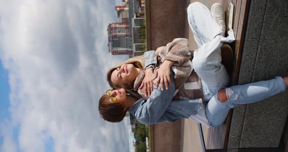 Two Lesbian Women Sit on the Embankment and Enjoy Each Other