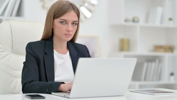 Appreciative Businesswoman with Laptop Saying Yes By Head Shake 