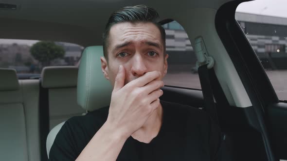 Sad Desperate Man Crying While Sitting in the Car. Shocked Man Crying Upon Hearing the Bad News