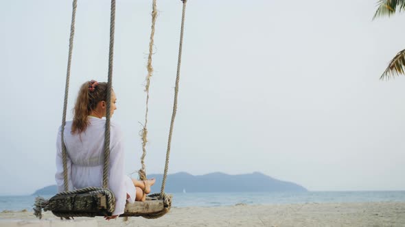 Woman on the Swing on Tropical Beach