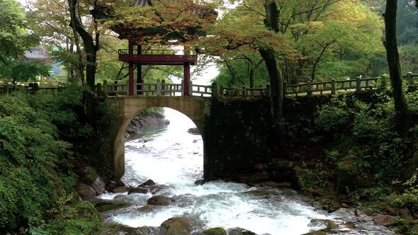 Mountain stream flows through arch of Korean foot bridge