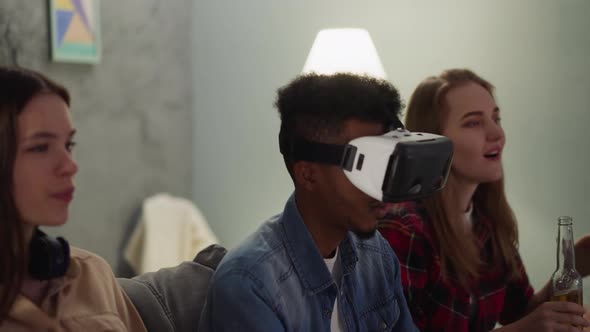 Black Guy with Vr Headset Sits Between Women at Baseball