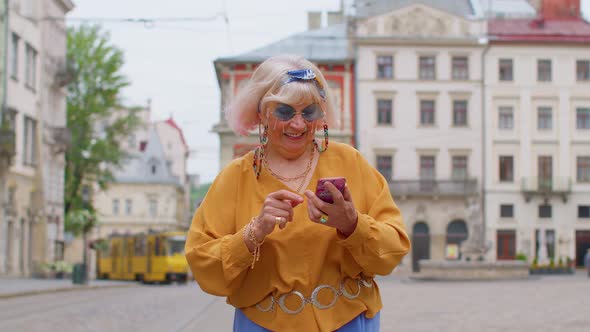 Elderly Stylish Tourist Woman Looking for Way Find Route Using Smartphone in Old Town Lviv Ukraine