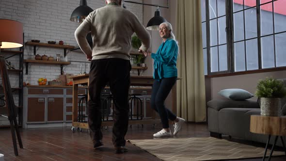 Joyful Aged Couple Dancing During Home Leisure
