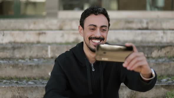 Front View of Arabic Man Having Video Chat Outside, Waving Hand