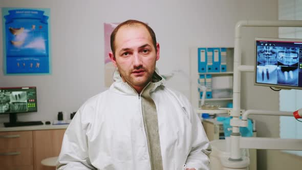 Portrait of Exhausted Stomatologist Man Taking Off Face Shield