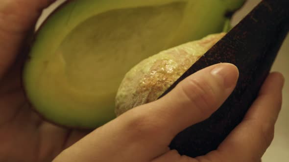 Opening Halved Avocado with Hands