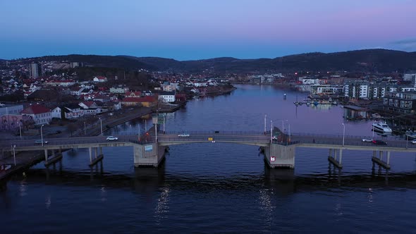 Porsgrunn city bridge - Late evening aerial showing traffic passing ove channel bridge at dawn - Cal