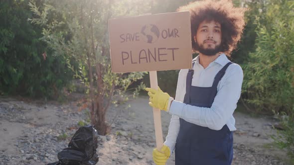 Portrait of Male Curly Activist Holding Save Our Planet Poster