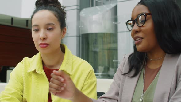 Multiethnic Businesswomen Working on Laptop and Talking in Office