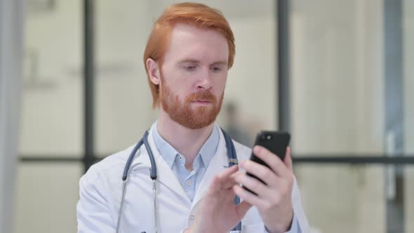 Portrait of Redhead Male Doctor Using Smartphone at Work 