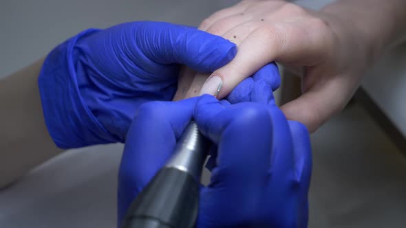 manicure master using a machine to clean the nails