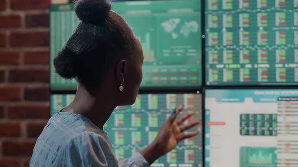 Female Investor Analyzing Multiple Monitors with Trade Market Statistics