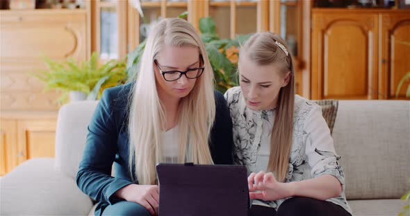 Two Womans Working on a Project on Digital Tablet at Home Office